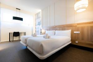 圣塞瓦斯蒂安URBAIA ROOMS的一张大白色的床,位于酒店客房内