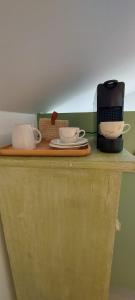 雅莱Cosy Corner的一个带两个杯子的柜台和咖啡壶