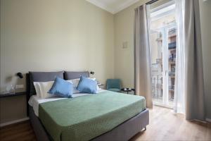 巴勒莫Mori's b&b的一间卧室配有一张带蓝色枕头的床和一扇窗户。