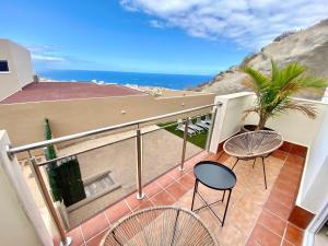 阿德耶Luxury Villa Masca private heated pool的阳台配有椅子,享有海景。