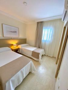 阿德耶Luxury Villa Masca private heated pool的酒店客房设有两张床和窗户。