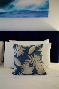 圣海伦斯Bay Of Fires Apartments的床上的枕头,上面有绘画作品