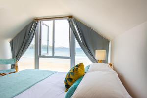 纽基托卡尼海滩公寓的一间卧室设有一张床和一个大窗户