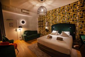 里尔卡纳伊酒店的一间卧室配有一张大床和一张绿色椅子