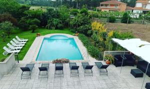 波瓦-迪瓦尔津Villa Casa Brandao的后院设有游泳池和一些椅子