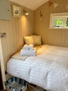 MountnugentSheelin Shepherds Hut 2 with Hot Tub的一间卧室配有带毛巾的床
