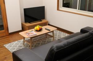 白马村乐博卡格木屋 - 白马八方木屋的客厅配有沙发和带电视的桌子