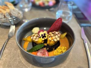 索米尔Hotel Restaurant Du Parc Saumur Logis Elégance的坐在桌子上的一碗食物