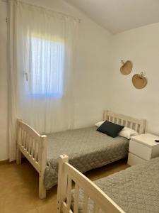 卡兰博希Villa Calma的一间卧室设有两张单人床和一个窗户。