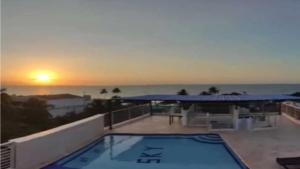 托卢Sky view hotel tolu的阳台上的游泳池,享有日落美景