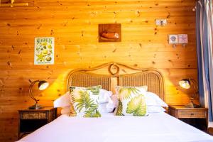 纽基Tolcarne Beach Cabins的卧室配有白色的木墙床