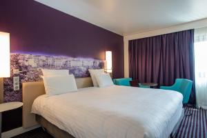 马赛美居马赛中心老城海港酒店的酒店客房带一张大床和椅子