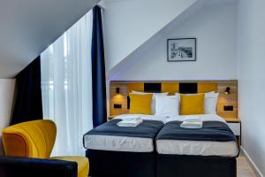 波别罗沃Apartamenty 111的一间卧室配有一张大床和一张黄色椅子