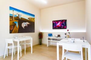 佩兹迪格雷科Dal Signor Wolf的一间设有白色桌子的用餐室和墙上的电视