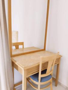 莱夫基米Alykes Family Resort的一张带镜子和椅子的木桌