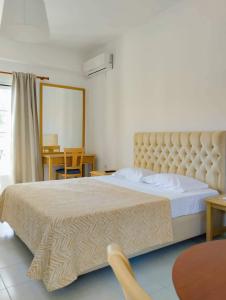 莱夫基米Alykes Family Resort的一间卧室配有一张大床和大床头板
