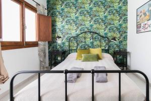 大加那利岛拉斯帕尔马斯El Rincón de los Artistas的一间卧室配有一张蓝色和绿色壁纸的床
