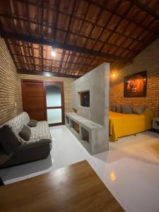 拉巴拉德纳圣安东尼奥Recanto da Crôa的客厅设有黄色沙发和壁炉