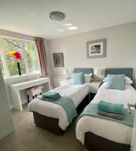 森嫩2 Bedroom cottage sleeps 4 with Hot-tub, & shared Pool use的一间卧室设有两张床和窗户。