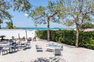 切萨雷奥港B&B Villa Massimo的一个带桌椅的庭院和海滩