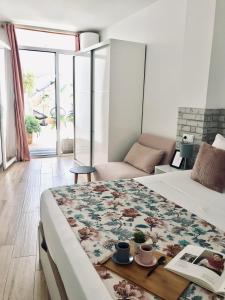 梅里达Apartamentos Élite - Art Collection - Frida的一间卧室,床上放着书和杯子