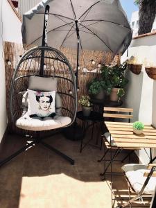 梅里达Apartamentos Élite - Art Collection - Frida的天井上配有带遮阳伞的秋千椅