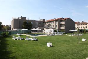 格拉迪斯卡迪松佐弗兰兹酒店的草坪,带椅子,游泳池和建筑