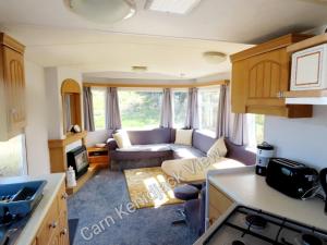 彭赞斯Carn Kenidjack View Caravan, space, peace and tranquillity的带沙发的客厅和厨房