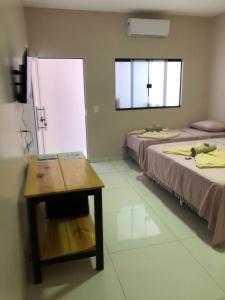 托坎廷斯州圣费利克斯Pousada Amanhecer no Jalapão的客房设有两张床、一张桌子和一扇窗户。