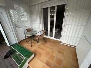 伊斯兰蒂拉Precioso apartamento con ubicación perfecta en playa Islantilla的门廊上配有桌椅的天井