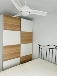 伊斯兰蒂拉Precioso apartamento con ubicación perfecta en playa Islantilla的一间卧室配有一张带吊扇的床