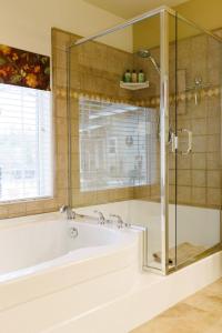 格罗夫兰红尾牧场酒店的带浴缸和玻璃淋浴间的浴室。
