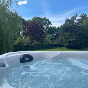 伍德哈尔温泉水疗Orchard View Lodge的一个带有树木的庭院内的按摩浴缸