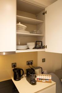 维亚纳堡Atrium Areias的厨房配有白色橱柜和餐具