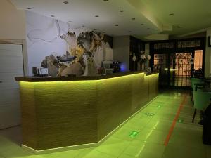 索托马里纳Hotel Ideal Sottomarina的一间酒吧,在一间房间里设有绿色的地板