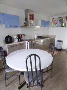 安格雷ANGLET petite Maison à 2 kms des plages et de Biarritz的厨房配有白色的桌椅