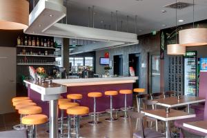 美因河畔法兰克福法兰克福机场梅宁阁酒店的餐厅的酒吧,有橘子凳