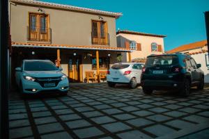 蒂拉登特斯Pouso Primavera的三辆车停在房子前面的停车场