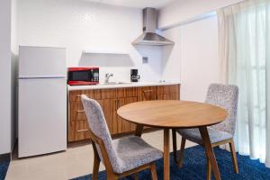 檀香山尔马酒店的厨房配有桌椅和冰箱。