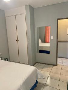 贝拉贝拉Bela-Bela Pendleberry Grove Unit 3的卧室配有白色的床和镜子