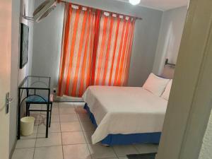贝拉贝拉Bela-Bela Pendleberry Grove Unit 3的一间卧室配有床和橙色窗帘的窗户