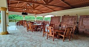 Los DestiladerosHotel Pacific Pearl - Playa Los Destiladeros的用餐室配有木桌和椅子