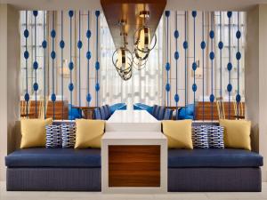 休斯顿休斯顿盖乐瑞圣淘沙ES套房酒店的客厅配有蓝色的沙发和吊灯。