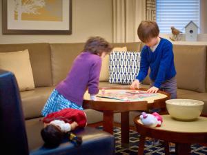 休斯顿休斯顿盖乐瑞圣淘沙ES套房酒店的男孩和女孩在客厅玩游戏