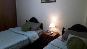 科尔多瓦Córdoba Te Espera的一间卧室配有两张床和一张带台灯的桌子