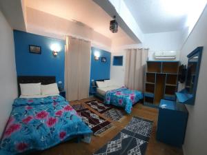 开罗happy life hostel的一间拥有蓝色墙壁的卧室,配有一张床和一张桌子