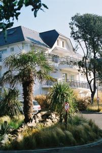 波尔尼谢雷斯当斯酒店的一座白色的大建筑,前面有一棵棕榈树