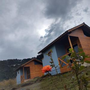 邦雅尔丁-达塞拉Cabanas Sol Poente的山坡上的房子,前面有花