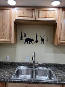 安克雷奇Nunaka Valley Cottage的厨房水槽设有鹿和墙上的熊
