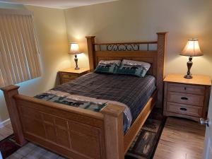 安克雷奇Nunaka Valley Cottage的一间卧室配有木床和2个床头柜